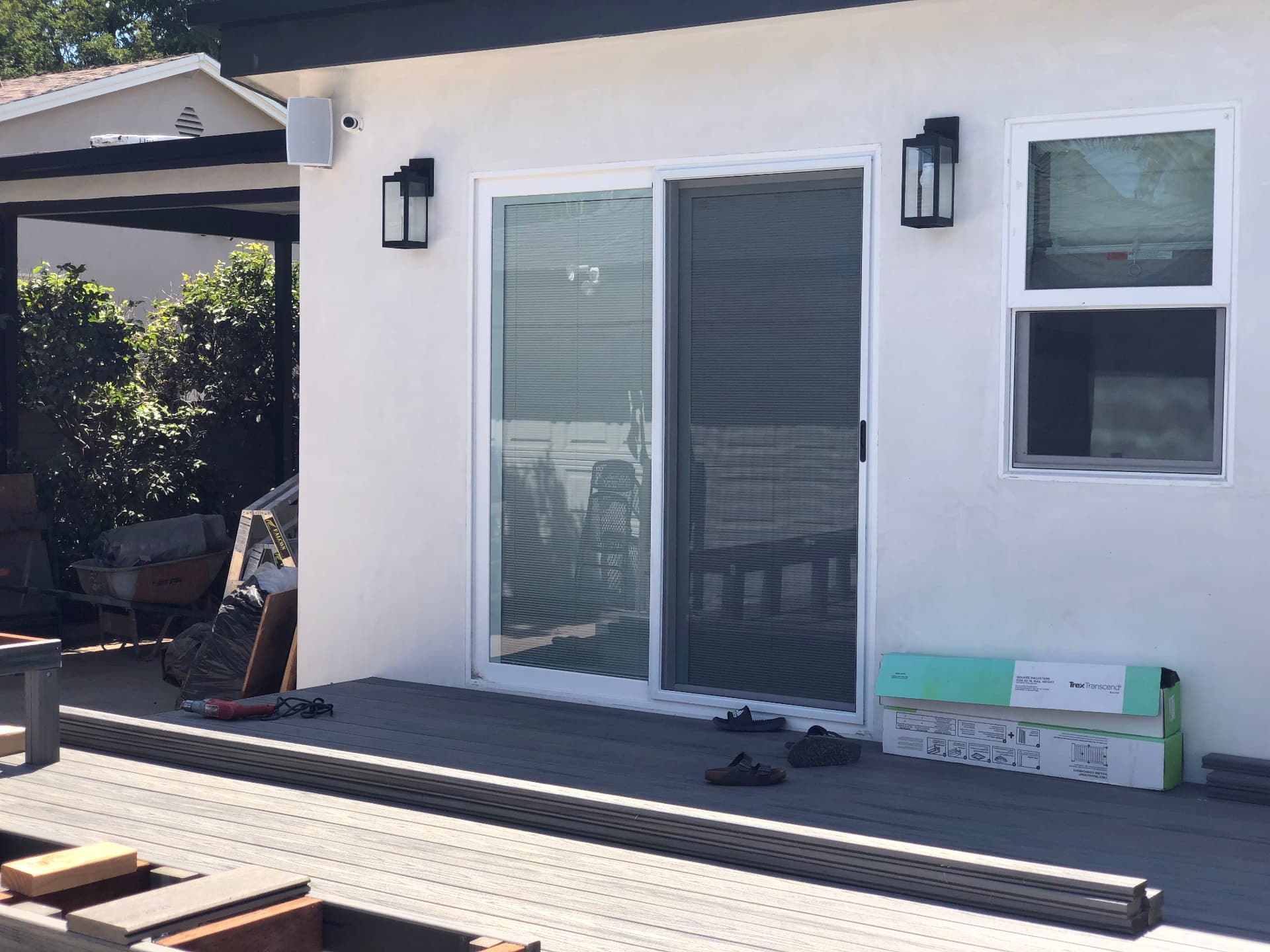 Contemporary backyard patio with wall-mounted outdoor speakers and covered deck during renovation